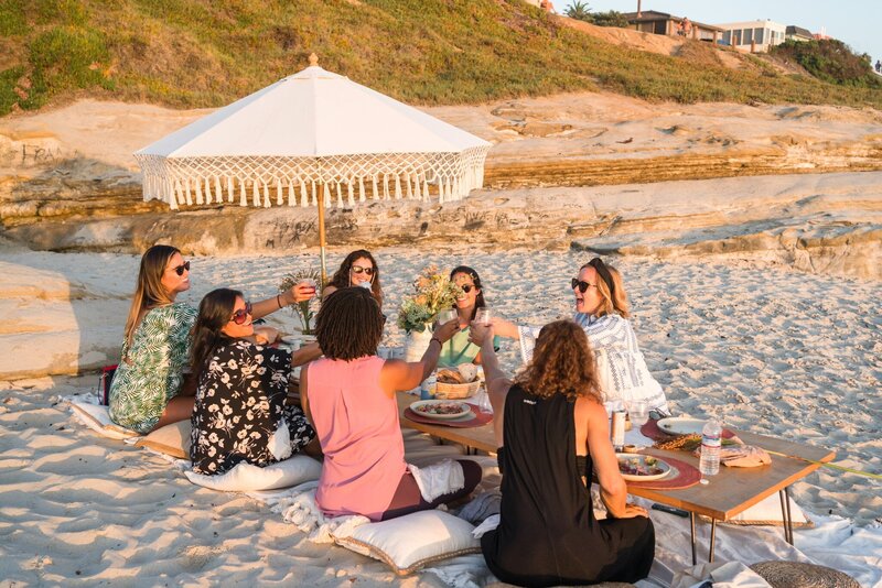 Girls Club community members toasting at Windansea at sunset