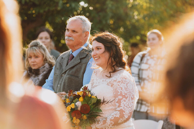 Emotional bride with father walking down aisle