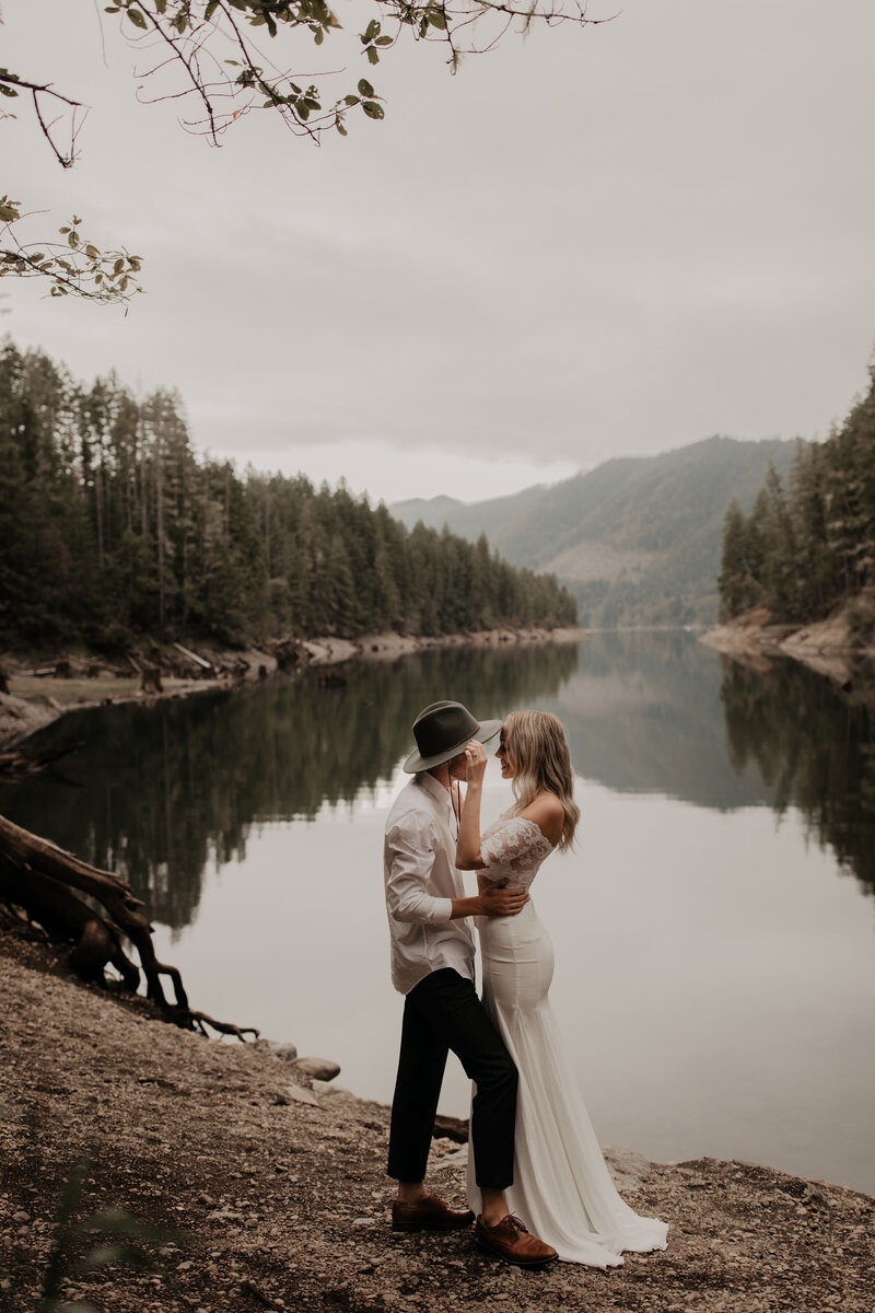 bride and groom sharing a kiss next to the lake