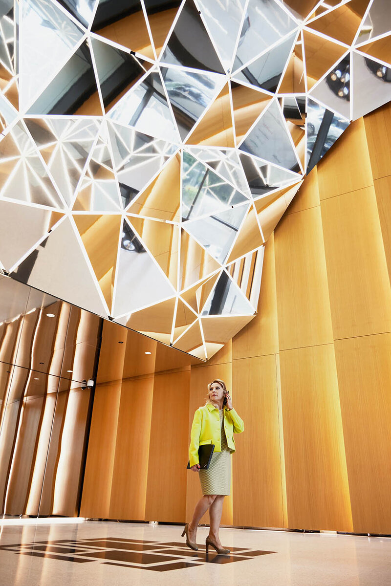 Roxana, a market researcher, walks through a designer lobby while talking on the phone