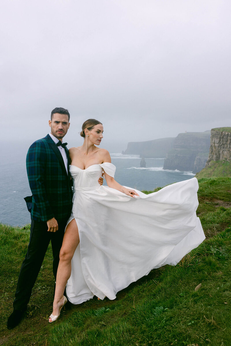 A couple posing for a photo during their elopement on the top of the cliffs of Moher