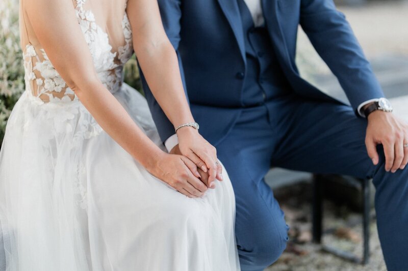 Close up of the hands of the two brides reading their private vows at the Peter Shields Inn suite