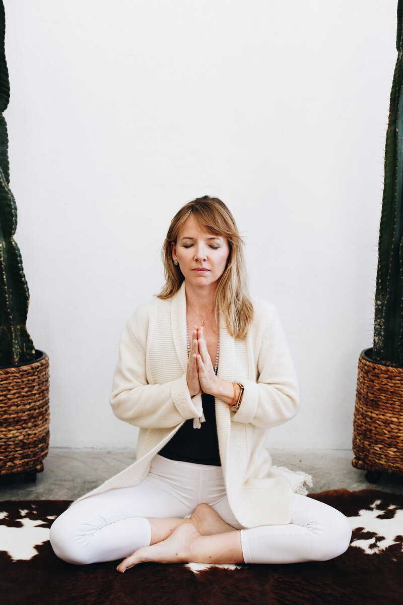 Leah in a calming yoga pose, embodying mindfulness and serenity, guiding others on their wellness journey through meditation and meditation coaching.