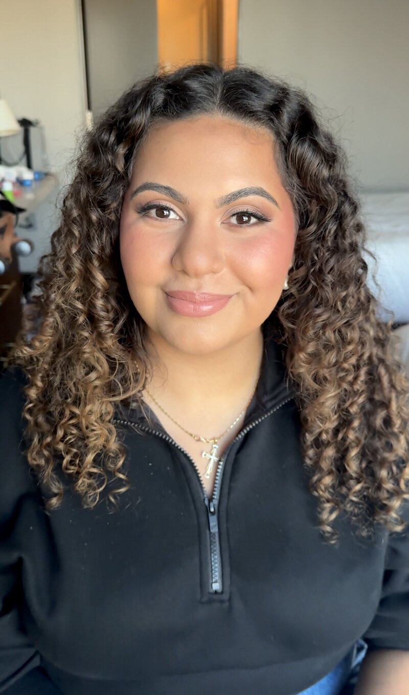 Bride smiling after just finishing her hair and makeup