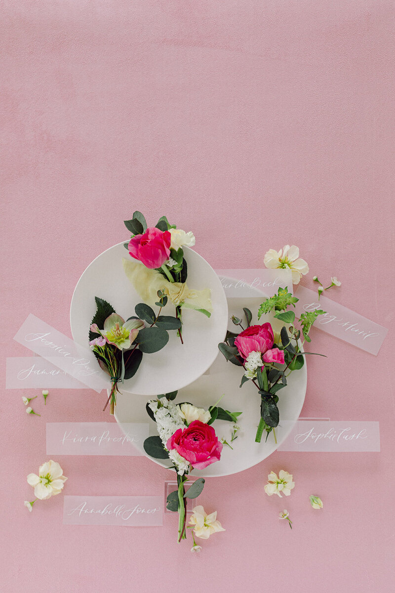 Light pink suede mat with blush-toned invitations and florals