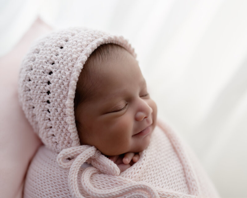 A rare and heartwarming newborn smile—wrapped in soft textures and joy.