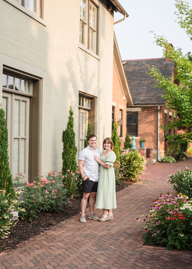 A couple hugs each other and smiles during their German Village engagement session