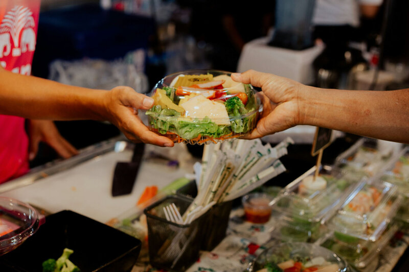 Person Handing Over Salad at a convenience store counter