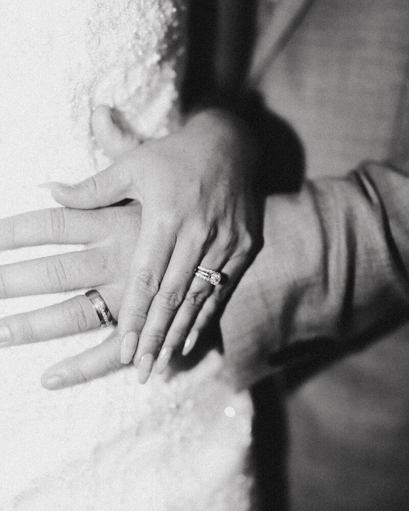 A film portrait of a husband and wife's hands with their new wedding rings - captured by Eilish Burt Photography in Whakatane