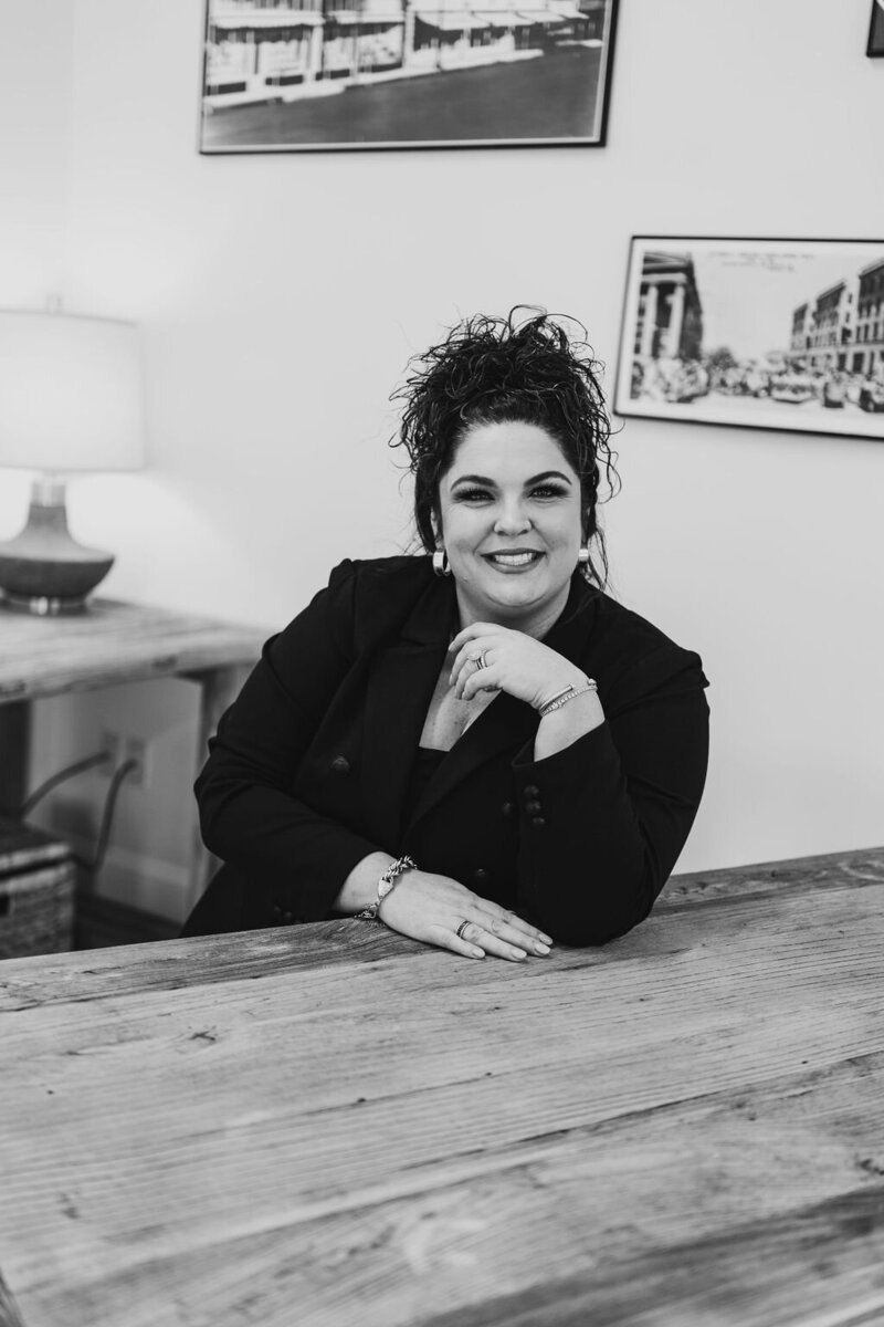 Photo of Paige Jordan, Realtor and Owner at Capital Realty Group posing at her desk.