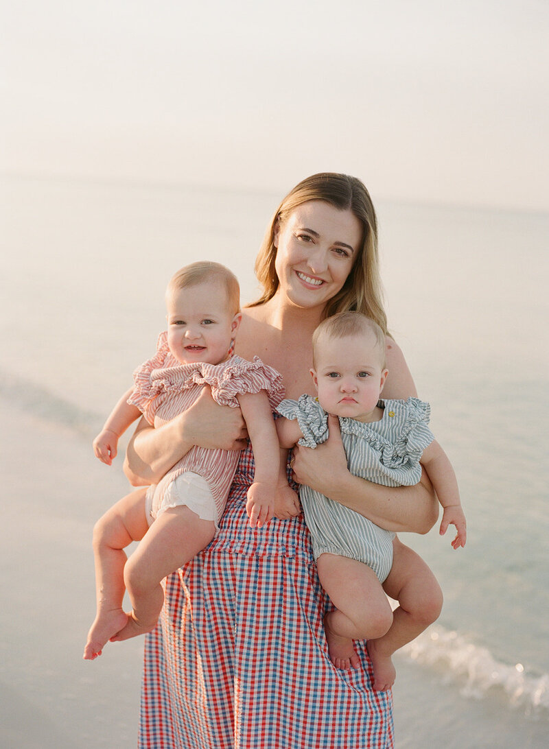 film photo of a young mom with her twin baby girls on the beach