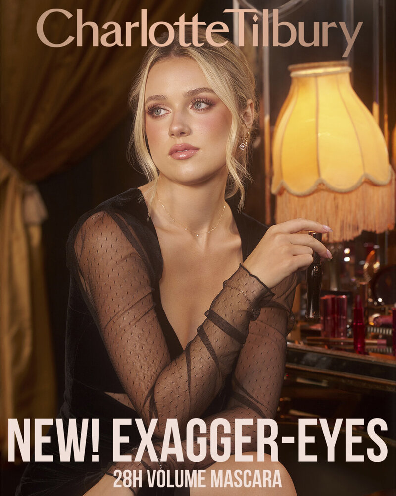 Yana Lina posing elegantly in a sheer black top for the Charlotte Tilbury 'Exagger-Eyes' 28H Volume Mascara campaign, photographed by Ylva Erevall.