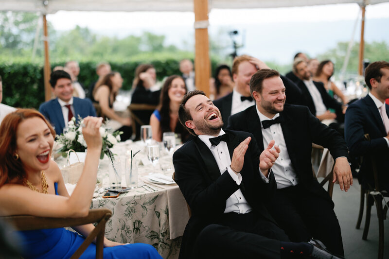Wedding guests sitting at tables and laughing