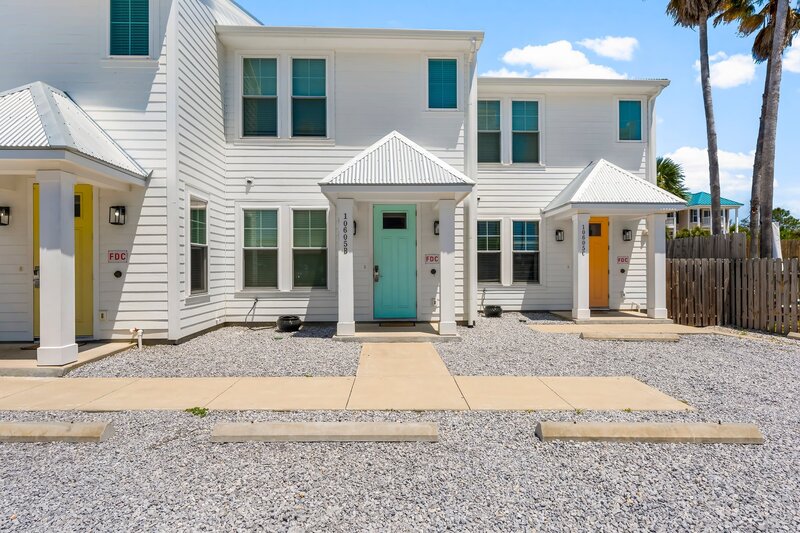 Front exterior of Groovy Shack showing the signature aqua blue door, a vibrant townhouse perfect for groups and families.