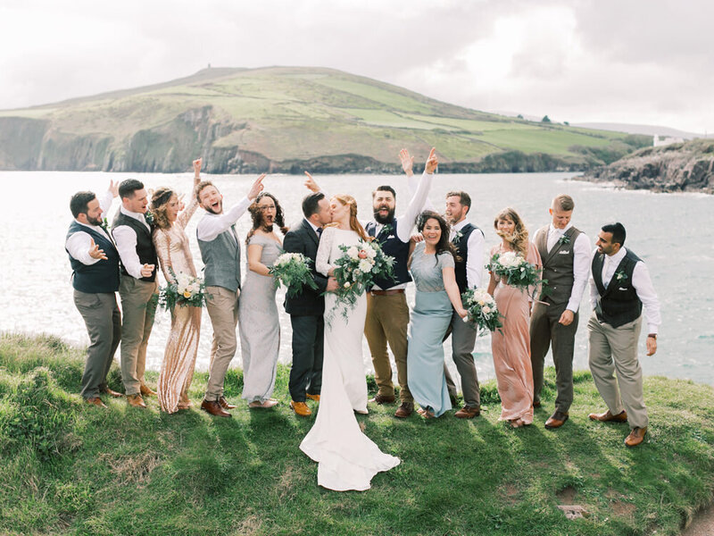 Wedding Party standing on a hill in front of the ocean in Dingle, Ireland. Ireland Destination Wedding Photographer