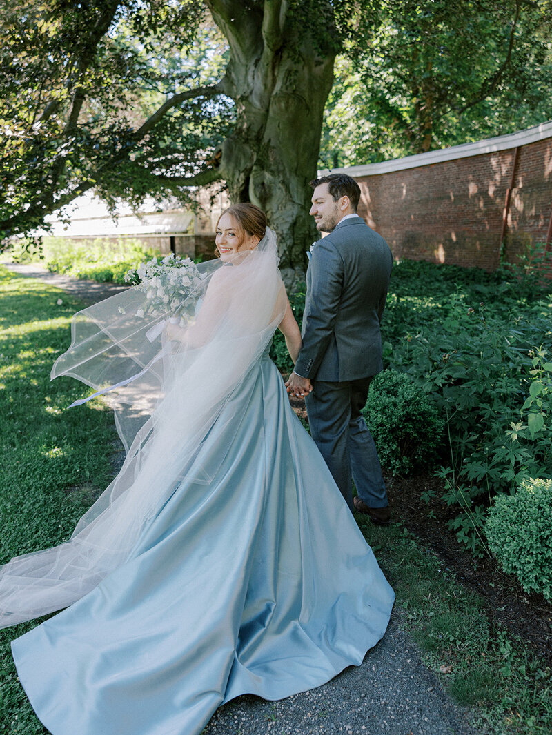Bride in blue gown walking with groom
