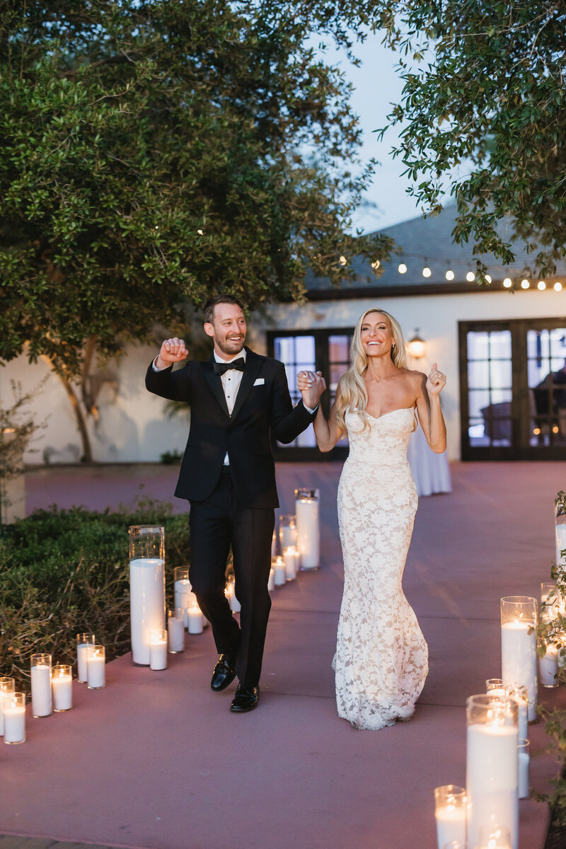 Newlywed couple holding hands entering reception at El Chorro in Arizona.