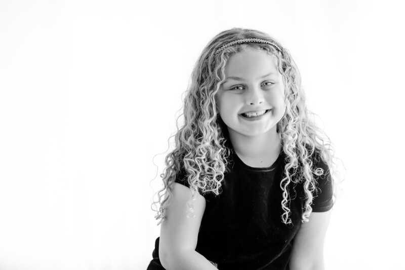 black and white personality portrait of a little girl smiling at the camera