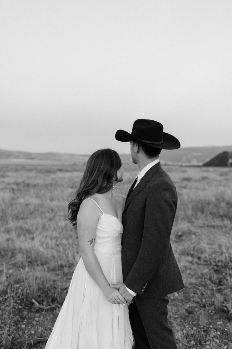 bride and groom holding hands in Grand Teton National Park looking behind them 