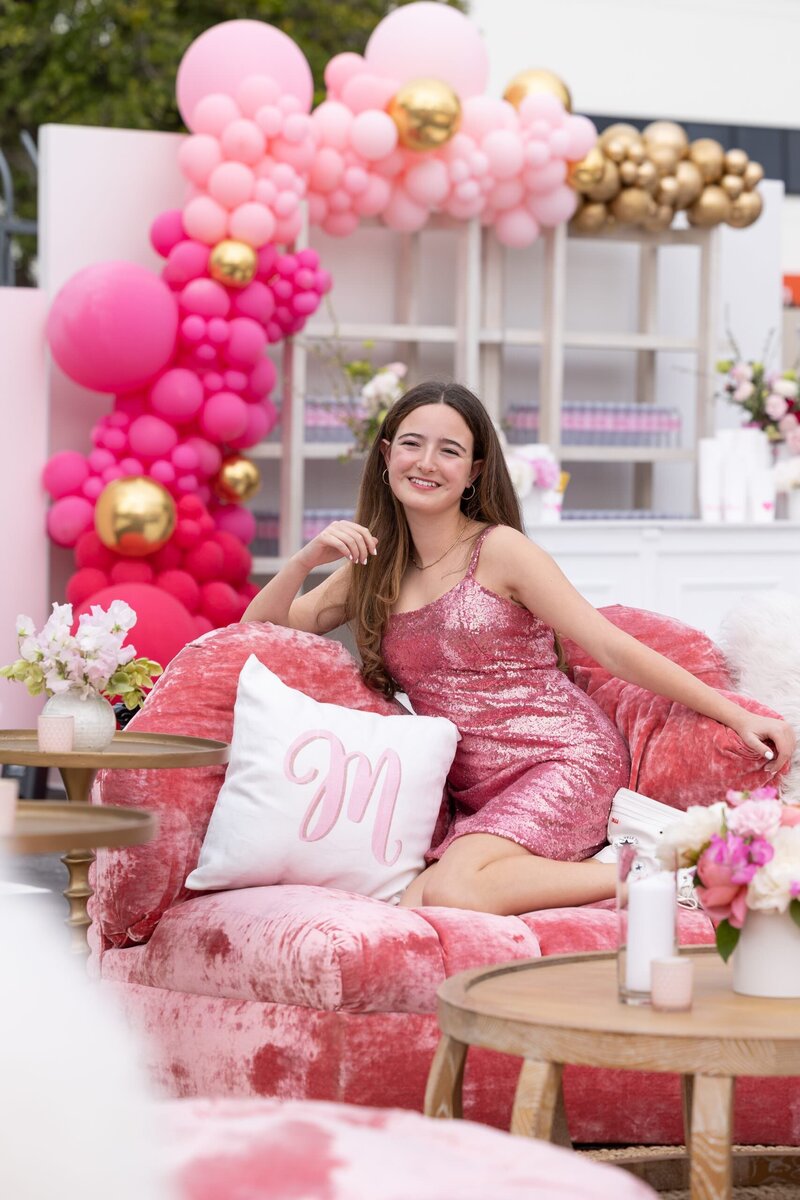 A girl sitting on a pink couch