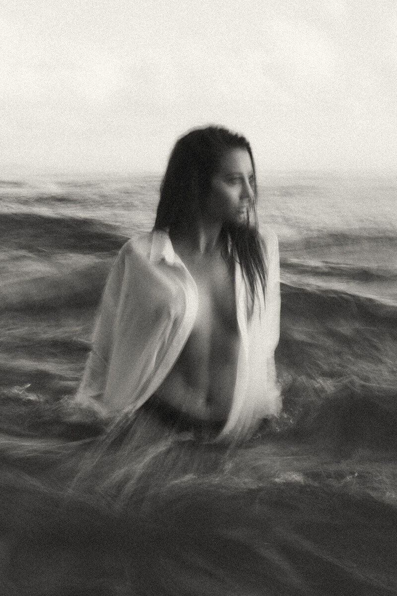 Cinematic black and white personal branding photography featuring a woman moving through the surf, captured with motion blur for a storytelling and emotive brand session. Artistic and raw brand photography for creative entrepreneurs on the Sunshine Coast.