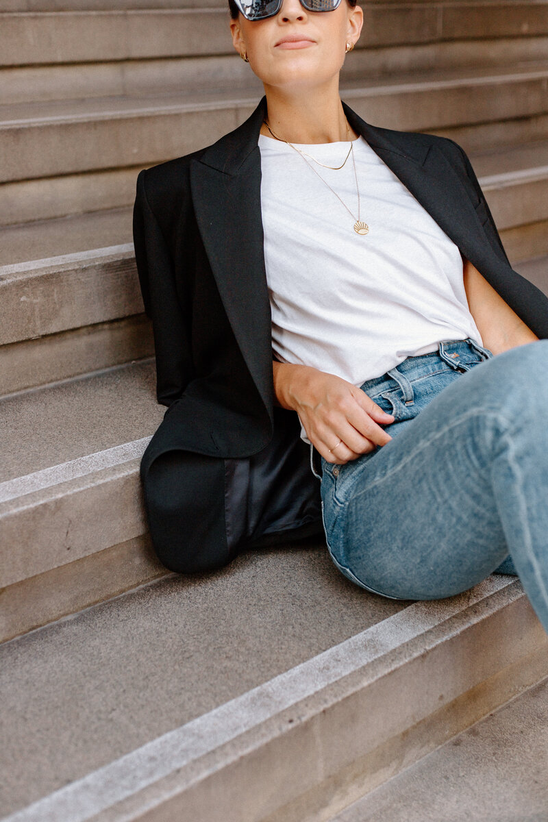 woman sitting with advocate white t shirt and blue denim jeans
