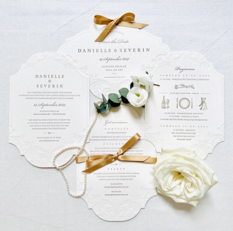 bespoke wedding stationery in white and gold with fresh flowers and pearls