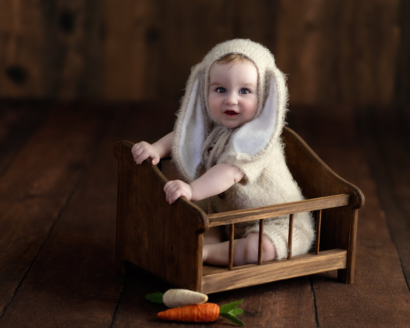 With his cozy bunny bonnet and vintage setting, this baby girl’s milestone session is a sweet nod to imagination and rustic styling.