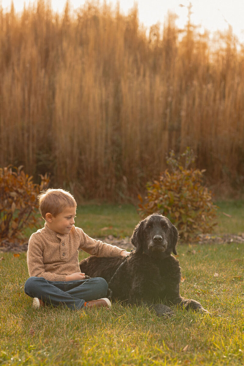young boy with his old dog at the park for relaxed family photos in Winnipeg 
