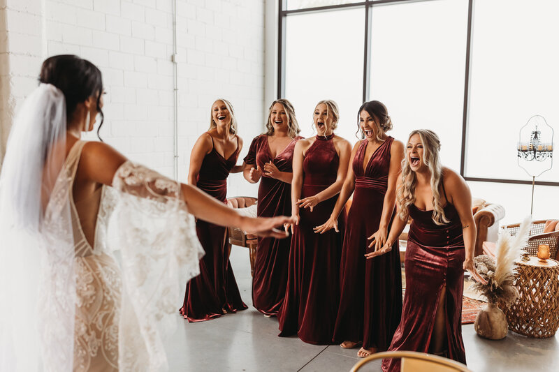 Wedding session photo with bride dress reveal to bridesmaids