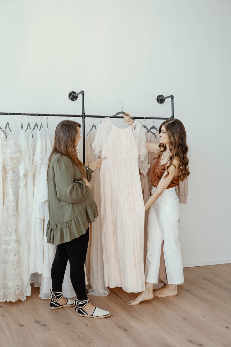 Babyfotografin sucht mit ihrer Kundin das perfekt Kleid für das Babybauchshooting aus.