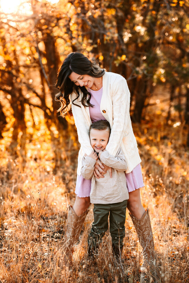 Mother and son dancing in the fall leaves at Buffalo Park in Flagstaff, AZ.