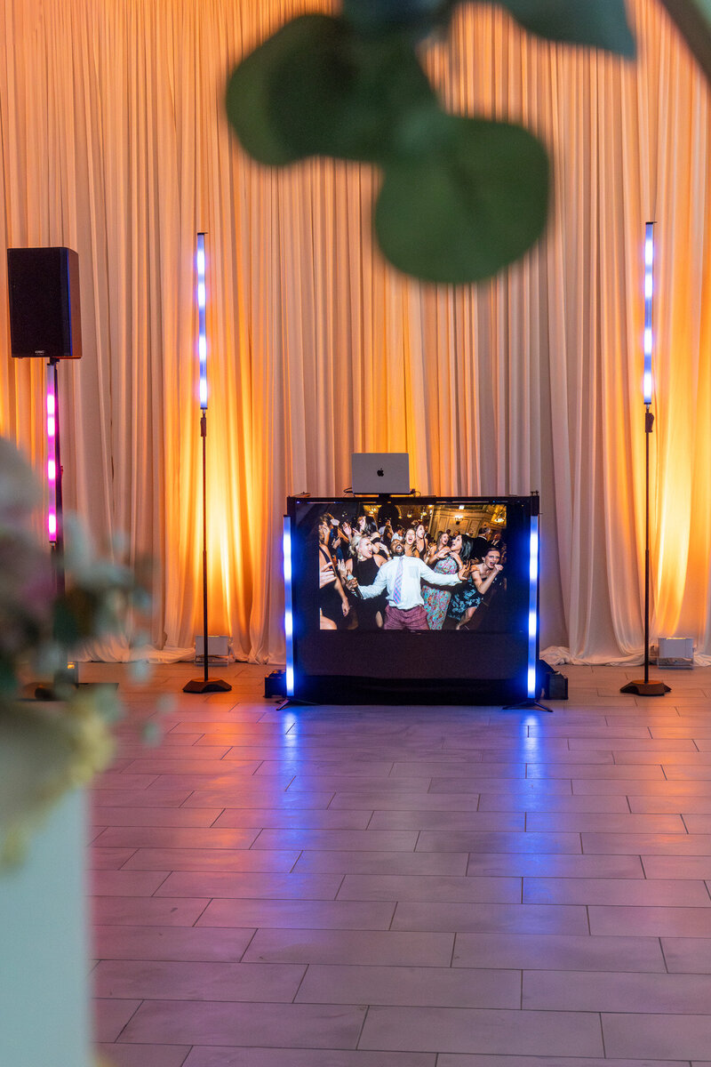 Chicago DJ booth with digital screen and uplighting in elegant indoor venue by Charizma Entertainment