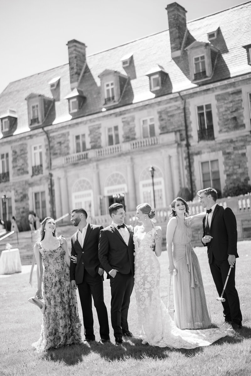 weddinng party playing bocci at cocktail hour on the lawn of a mansion in rhode island