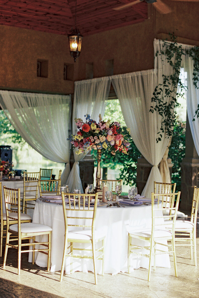 Colorful floral centerpiece at Tuscan garden wedding reception at Gervasi Vineyard.