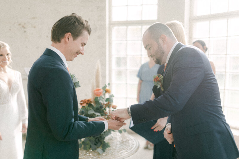 A documentary wedding  photo of the bestman giving the rings in a wedding ceremony in the orangerie in Oitbacka gård captured by wedding photographer Hannika Gabrielsson in Finland