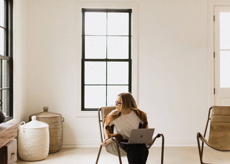 woman with computer turning to look out window