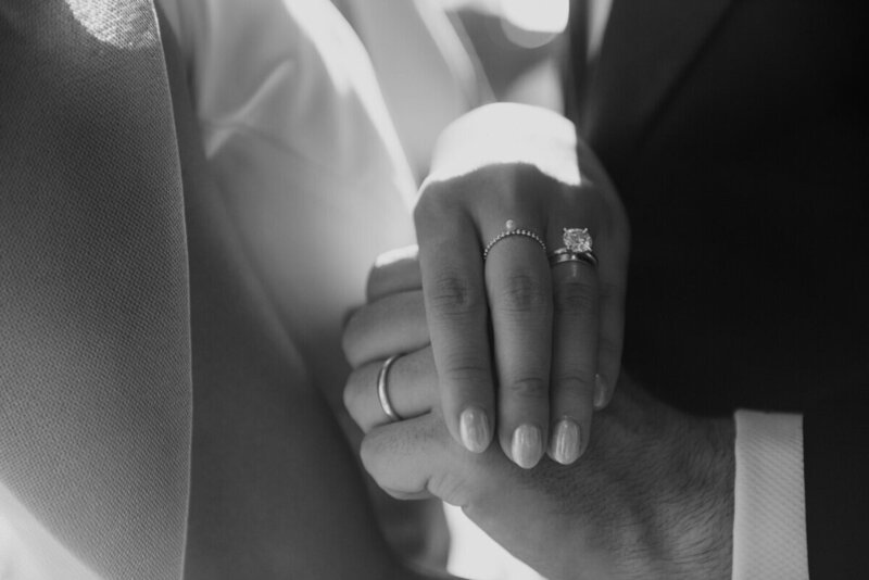 Bride and groom showing off their wedding rings.