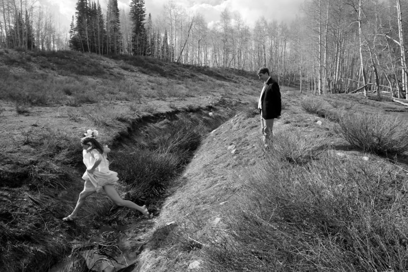 A bride jumps during a hike at a Utah  Wedding 