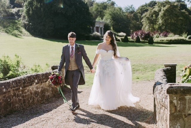 Bride and groom walking hand in hand at Wotton House