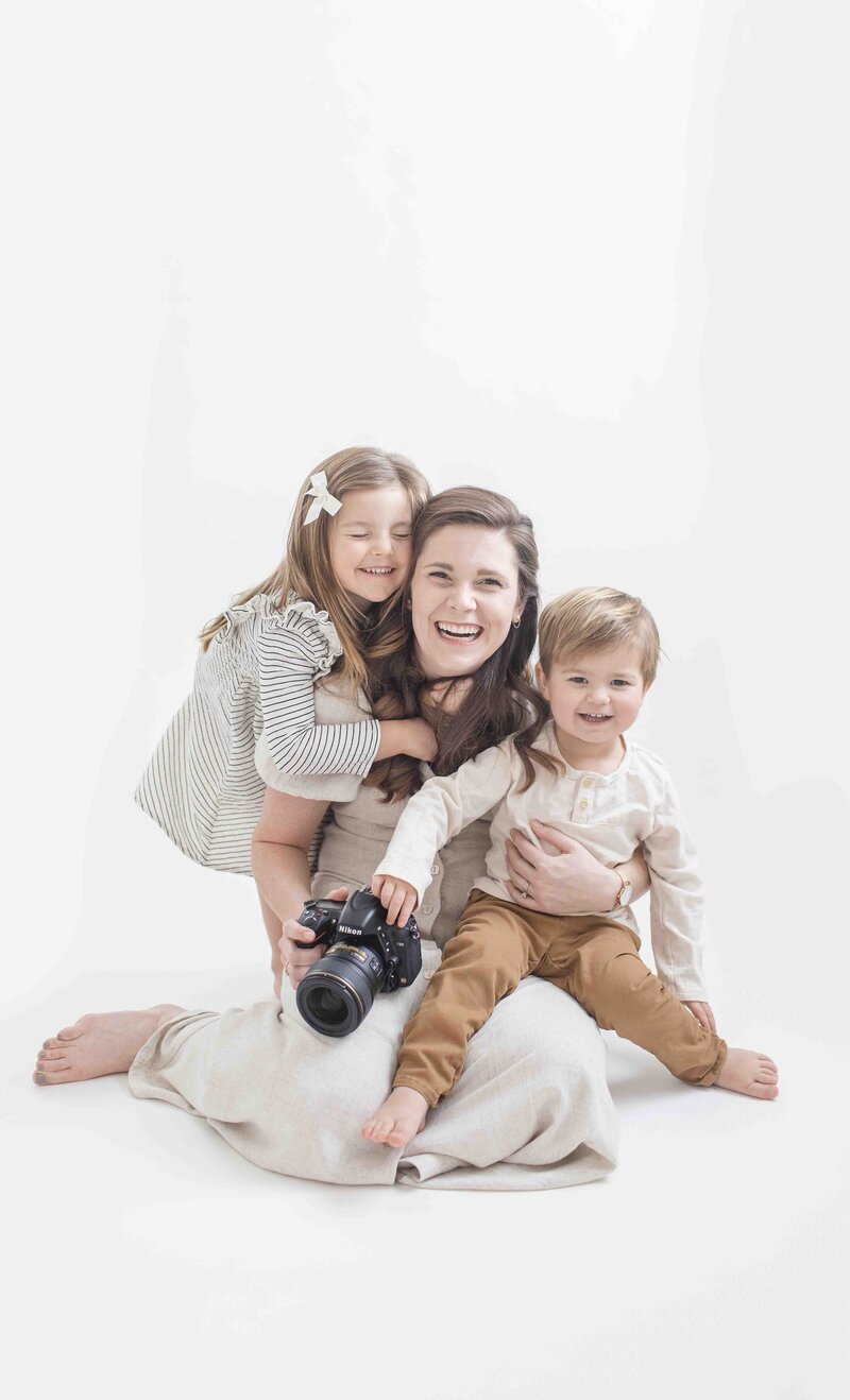 Woman holding camera and her two children