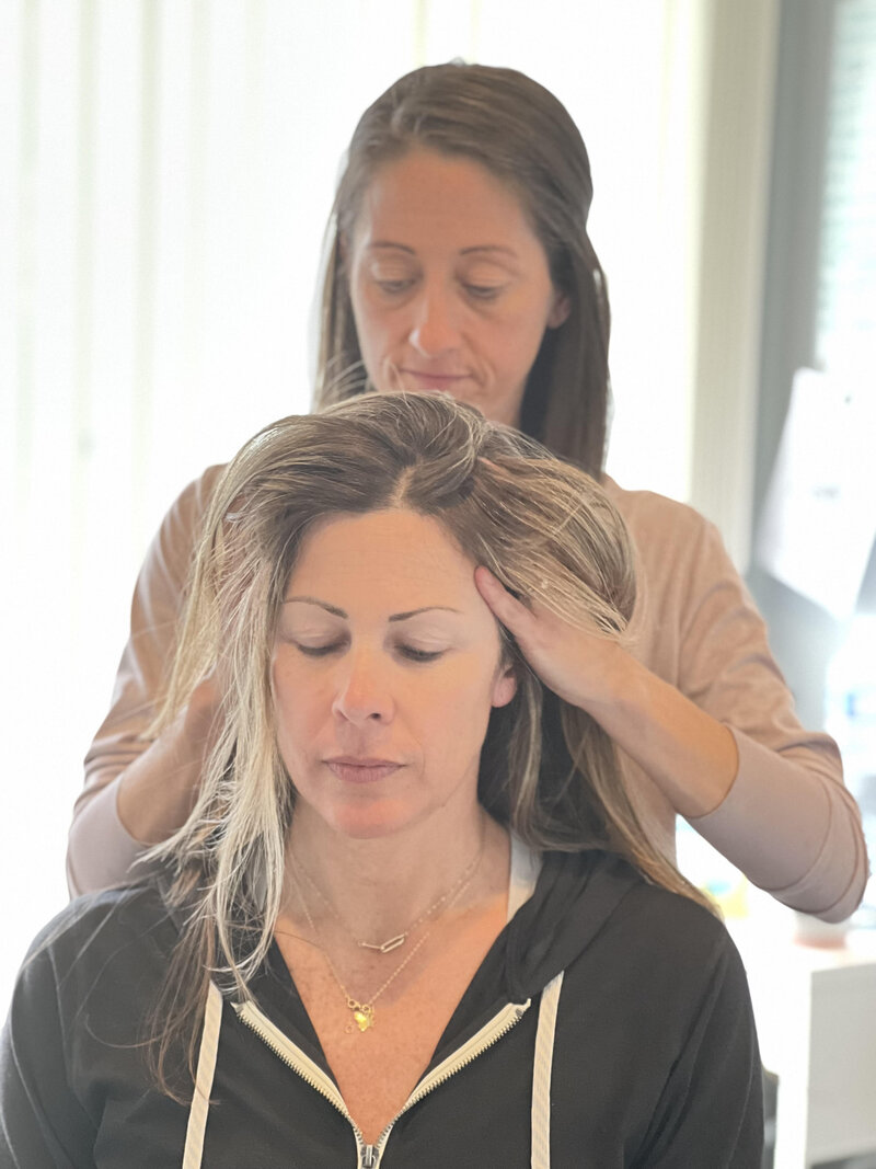 Amy using fascial counterstrain techniques on patients scalp.