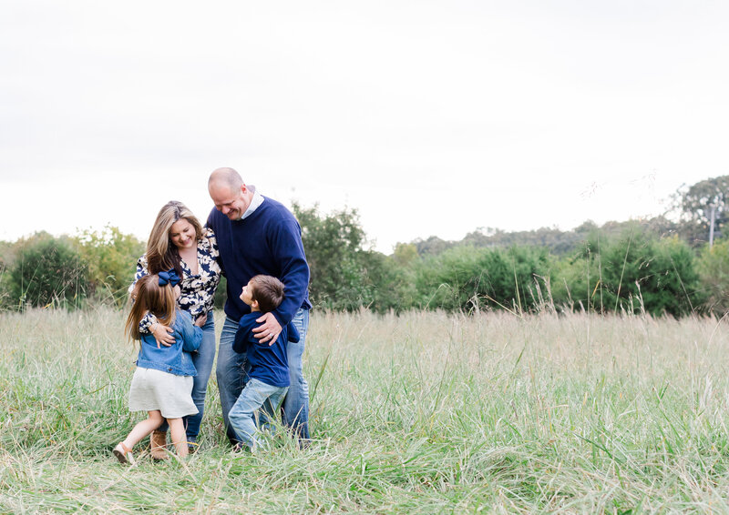family posing in a field for fall photos