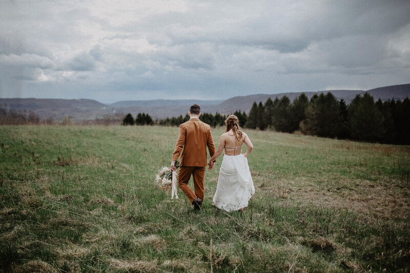 wedding couple walking away from camera in New England countryside