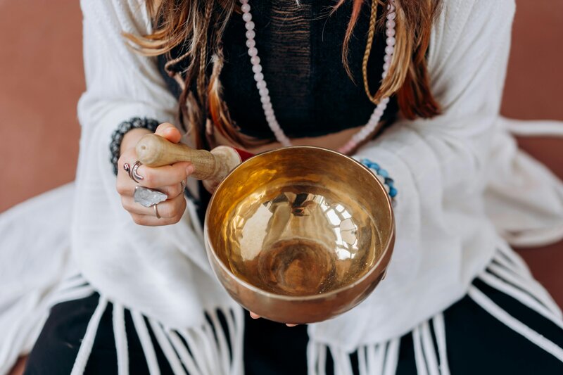 Women using a bowl during a sound bath