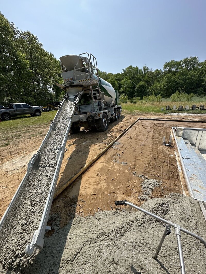 Pool deck pour: concrete coming down the truck chute beside the pool walls in Elkhart, IN