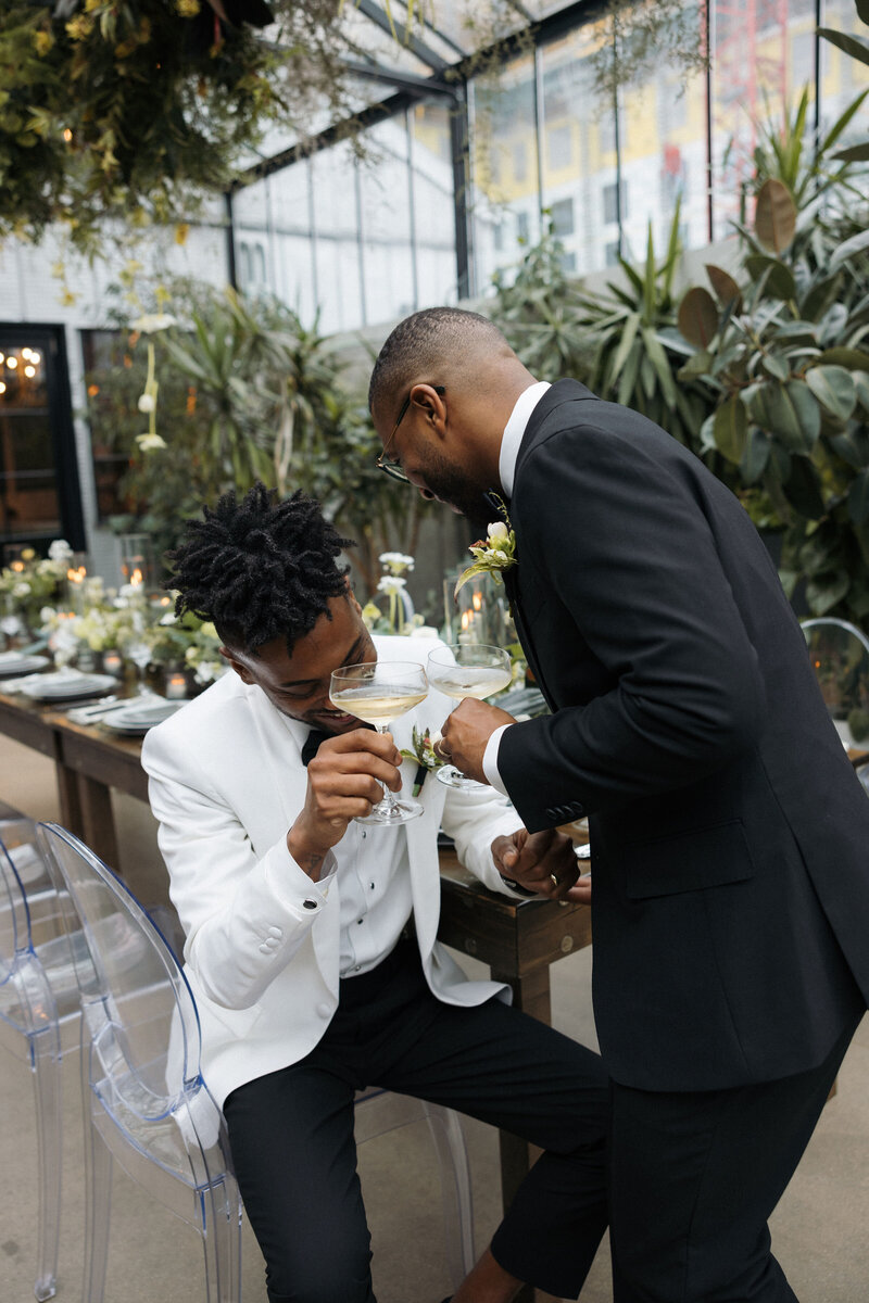LGBT couple making a toast to each other at their luxury wedding in Wisconsin Q Jancola