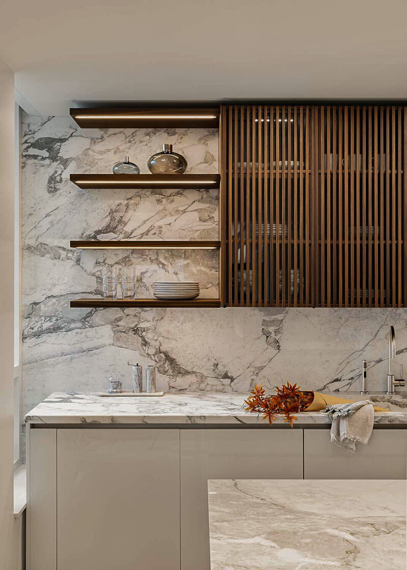 All custom, luxury kitchen with floating shelves, bi-fold cabinetry doors and natural stone clad walls by Sister Studio.