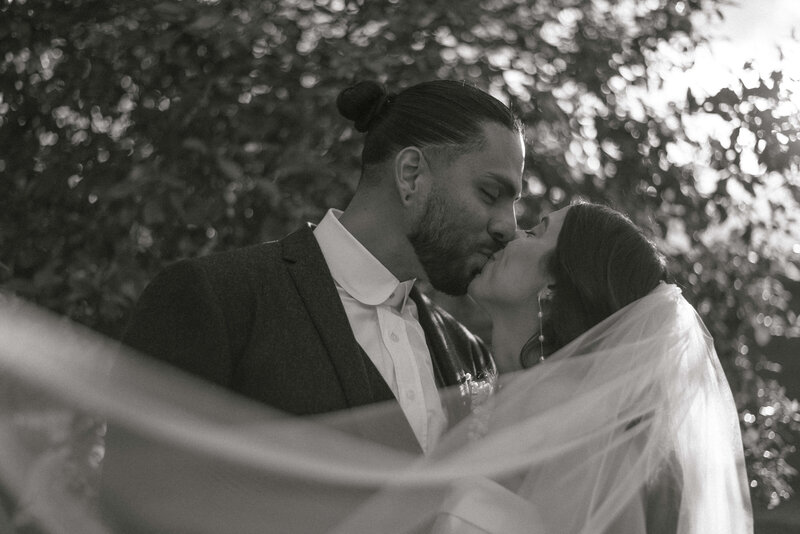 Bride and Groom Kissing with Veil In Foreground