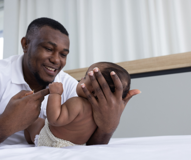 Black father smiling at his newborn baby